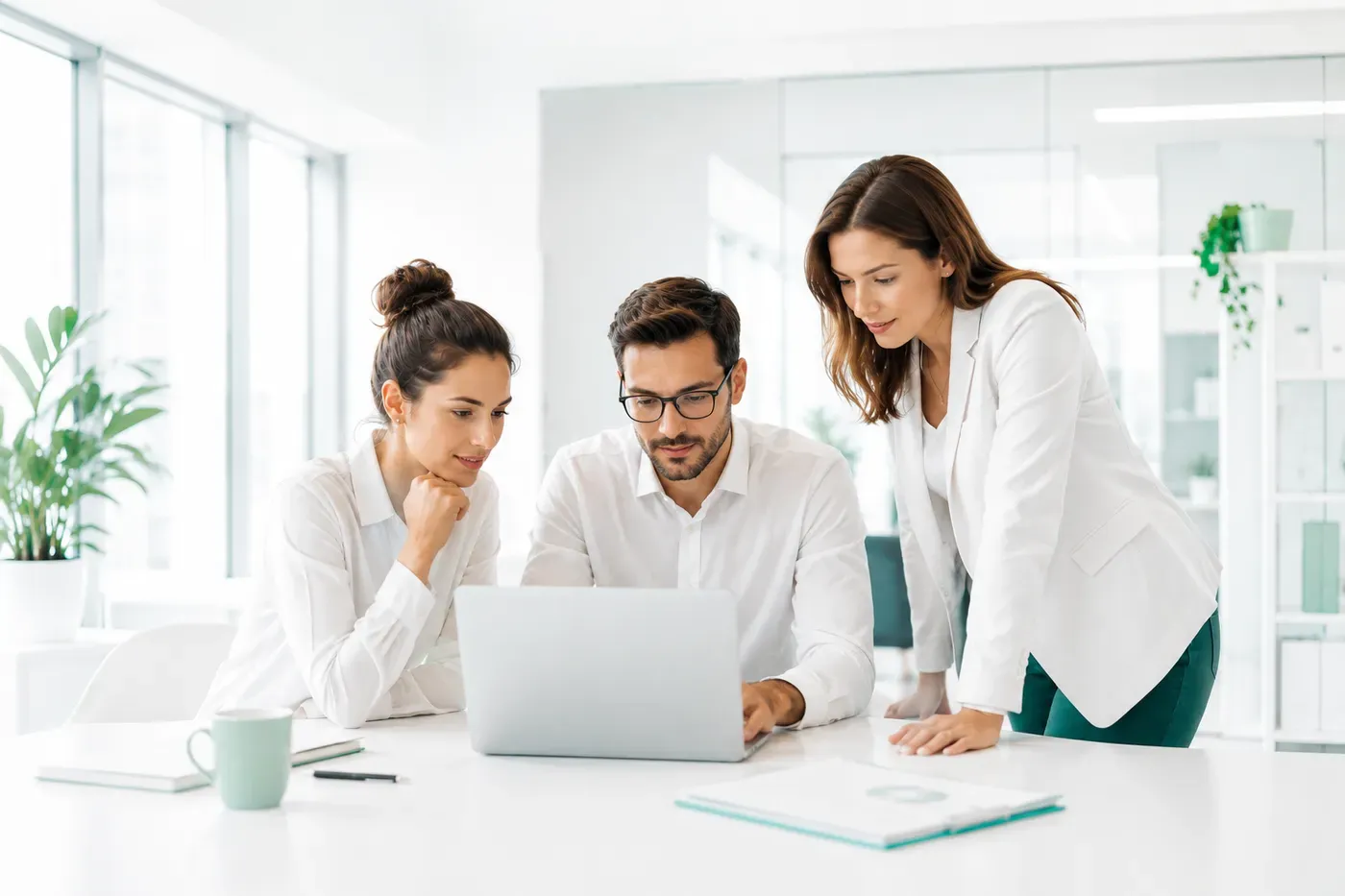 Ein Team sieht sich Unternehmensdokumente auf einem Laptop im Büro an